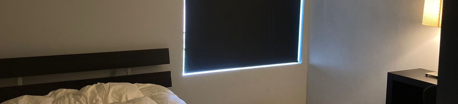 Custom blackout roller shades installed in a Santa Clarita bedroom, providing total light control and privacy.